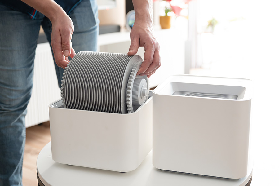 Man installing a replacement filter in a modern humidifier